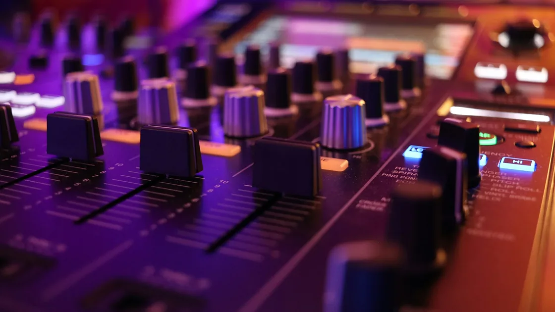 Mesa de mezclas de un estudio de grabación con faders, potenciómetros y luces de canal
